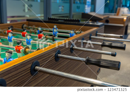 Retro table soccer with wooden miniature figurines of players on metal bars 123471325