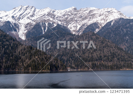 Mountains Lake Caucasus Spring: Snow-capped peaks reflect in calm lake waters, showcasing Caucasus mountain range's springtime beauty. 123471395