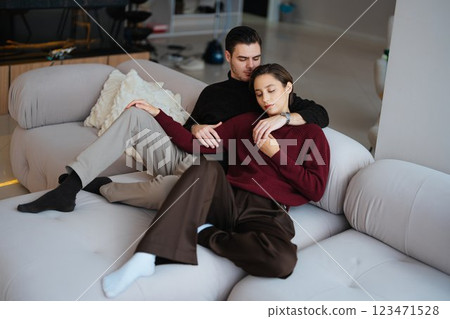 Couple relaxing together on a modern sofa in a cozy living room setting 123471528