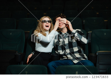 Joyful couple enjoying a fun moment in a movie theater during evening show Joyful couple enjoying a fun moment in a movie theater during evening show 123471633