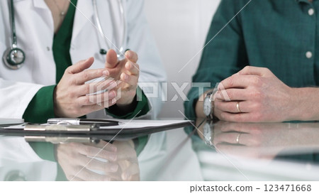 Doctor using hand gestures to explain diagnosis to patient during medical consultation, providing support and guidance for healthcare decisions Doctor using hand gestures to explain diagnosis to patient during medical consultation, providing support and guidance for healthcare decisions 123471668