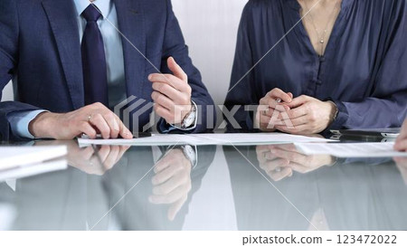 Business partners or lawyers are reviewing contract terms during a meeting, negotiating and making decisions together. Business people concept, close up view Business partners or lawyers are reviewing contract terms during a meeting, negotiating and making decisions together. Business people concept, close up view 123472022