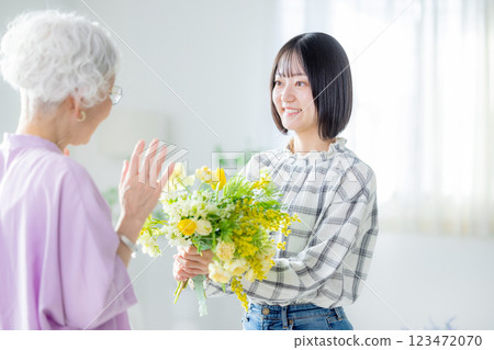 Woman handing over a bouquet of flowers on Respect for the Aged Day 123472070