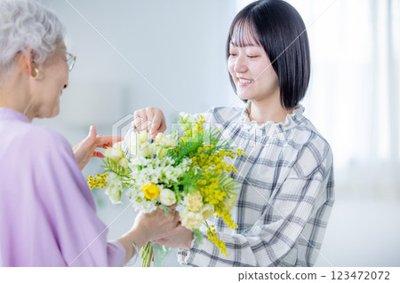 Woman handing over a bouquet of flowers on Respect for the Aged Day 123472072