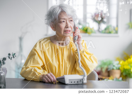 老婦人打電話時一臉焦急 123472087