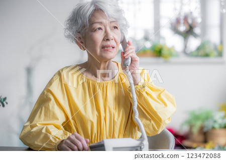 Senior woman making a phone call with an anxious face 123472088