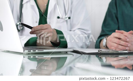Female doctor showing medical exam results on a laptop to a patient during a visit at the clinic, healthcare and medical consultation concept Female doctor showing medical exam results on a laptop to a patient during a visit at the clinic, healthcare and medical consultation concept 123472267