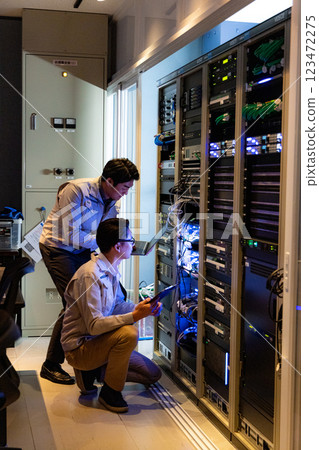 Engineers having a meeting in front of the server Engineers having a meeting in front of the server 123472275