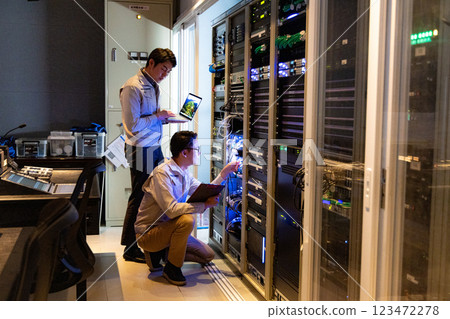 Engineers having a meeting in front of the server Engineers having a meeting in front of the server 123472278