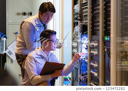 Engineers having a meeting in front of the server 123472282