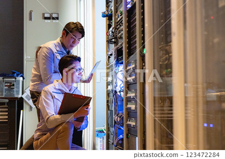 Engineers having a meeting in front of the server Engineers having a meeting in front of the server 123472284