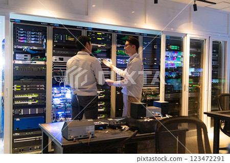 Engineers having a meeting in front of the server Engineers having a meeting in front of the server 123472291
