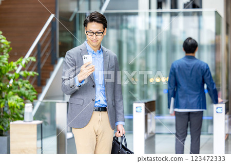 商人拿著智慧型手機在檢票口前 123472333