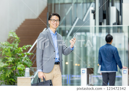 商人拿著智慧型手機在檢票口前 123472342