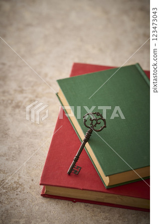 Antique key on top of an old book Antique key on top of an old book 123473043