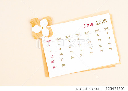 June 2025 calendar with origami flower paper on beige color. 123473201