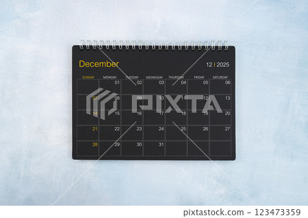 Blank calendar for December 2025, Black spiral desktop calendar on wooden background. Blank calendar for December 2025, Black spiral desktop calendar on wooden background. 123473359