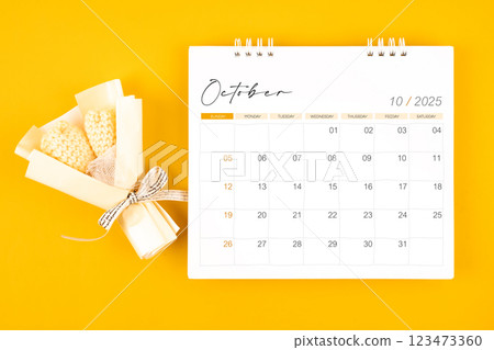 2025 October desk calendar and Yellow bouquet on yellow background. 2025 October desk calendar and Yellow bouquet on yellow background. 123473360