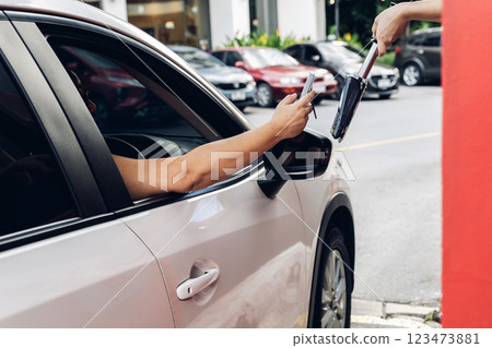 Hand Man in car receiving coffee in drive thru fast food restaurant. 123473881