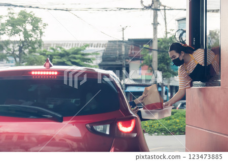 Hand Man in car receiving coffee in drive thru fast food restaurant. 123473885