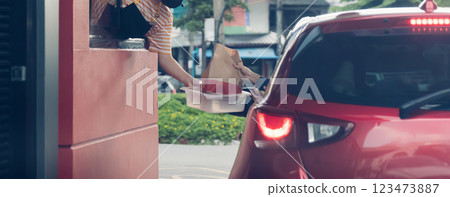 Hand Man in car receiving coffee in drive thru fast food restaurant. 123473887