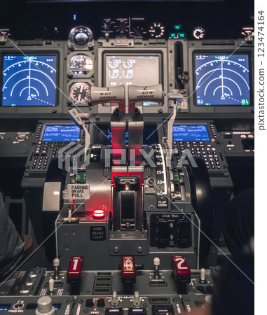 Cockpit view of an airplane during a night-time flight with illuminated instrument panels 123474164