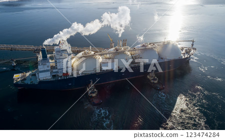 Aerial of Liquified Natural Gas LNG carrier moored to a small gas terminal at night. Fuel crisis. Sanctions. 123474284