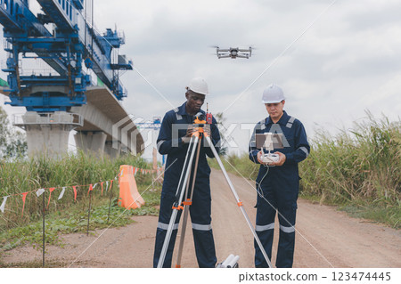 Engineer surveyor team Use drone for operator inspecting and survey construction site. 123474445