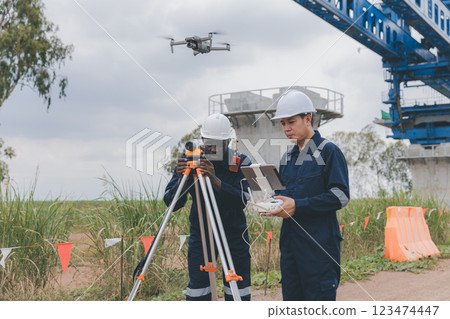 Engineer surveyor team Use drone for operator inspecting and survey construction site. 123474447