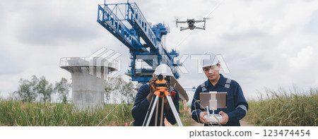 Engineer surveyor team Use drone for operator inspecting and survey construction site. 123474454