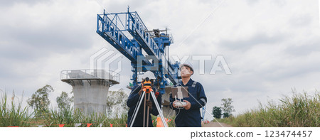 Engineer surveyor team Use drone for operator inspecting and survey construction site. 123474457