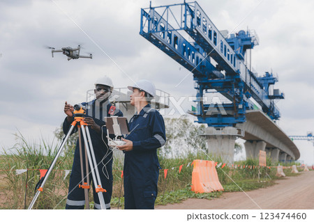 Engineer surveyor team Use drone for operator inspecting and survey construction site. Engineer surveyor team Use drone for operator inspecting and survey construction site. 123474460