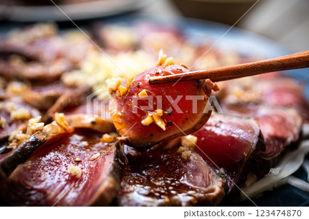 Fresh seared bonito picked up with chopsticks 123474870