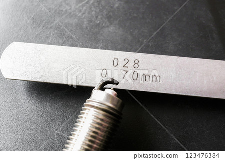 Close up of spark plug and feeler gauge or thickness gauge to adjust the gap of spark plug Close up of spark plug and feeler gauge or thickness gauge to adjust the gap of spark plug 123476384