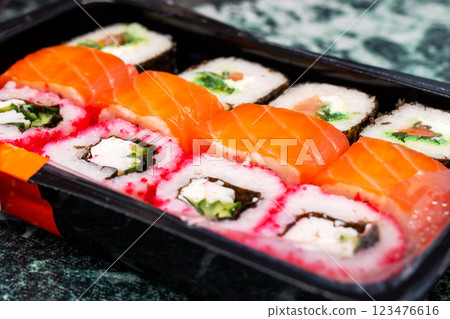 A plastic container that is filled with various types of sushi A plastic container that is filled with various types of sushi 123476616