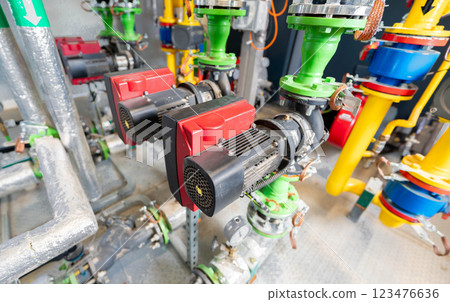 Industrial circulation pumps with electric motors connected to a complex piping system Industrial circulation pumps with electric motors connected to a complex piping system 123476636