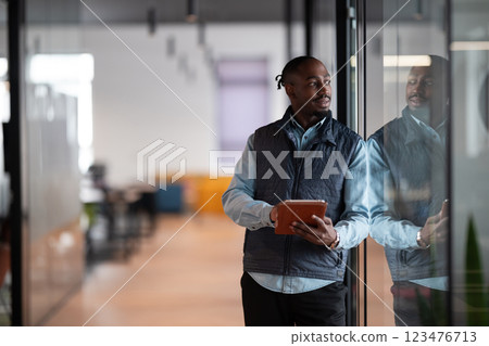 A confident, mature businessman in his 40s-50s using a tablet in a modern office. He is engaged in digital finance management, leveraging technology and artificial intelligence for investment 123476713