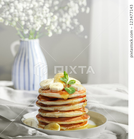 Delicious Pancakes Artfully Topped with banana slices and Golden Honey 123477143