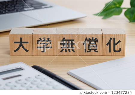 A block with the words "free college education" written on it on a table 123477284