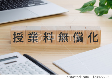 桌上有一塊寫著「免學費」的木板 123477298