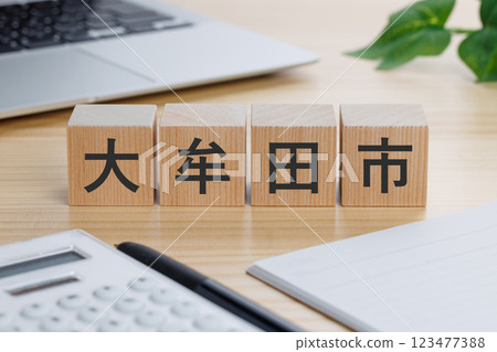 A block with the word Omuta written on it on the table 123477388