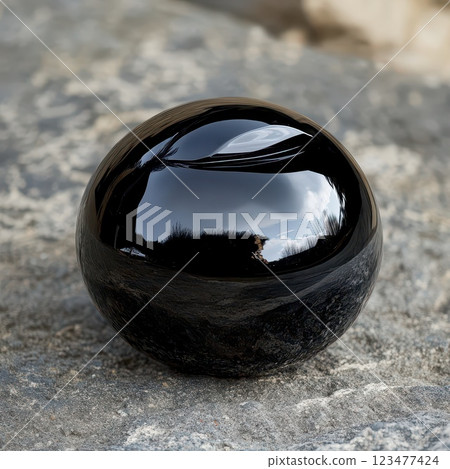 Dark sphere on natural stone surface 123477424