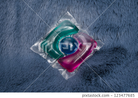 Washing gel capsule on material textile background Washing gel capsule on material textile background 123477685