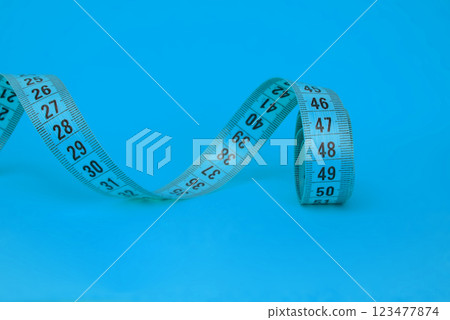 Spiral blue tape measure colorful background with copyspace 123477874