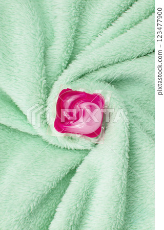 Washing gel capsule on material textile background Washing gel capsule on material textile background 123477900
