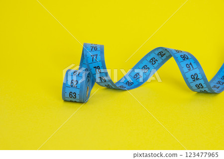 Spiral tape measure colorful background with copyspace 123477965