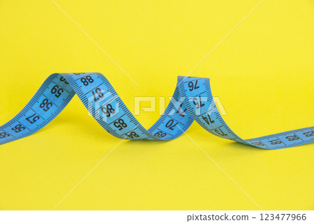 Spiral tape measure colorful background with copyspace Spiral tape measure colorful background with copyspace 123477966