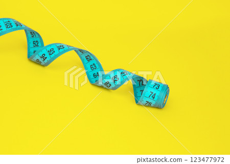 Spiral tape measure colorful background with copyspace Spiral tape measure colorful background with copyspace 123477972