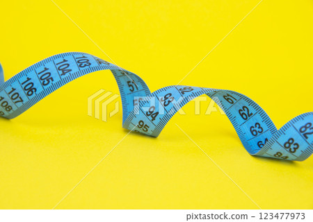 Spiral tape measure colorful background with copyspace Spiral tape measure colorful background with copyspace 123477973
