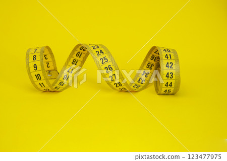Spiral tape measure colorful background with copyspace Spiral tape measure colorful background with copyspace 123477975